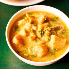 veg kurma or korma in a white bowl on a dark green wooden tray