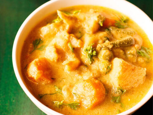 veg kurma or korma in a white bowl on a dark green wooden tray