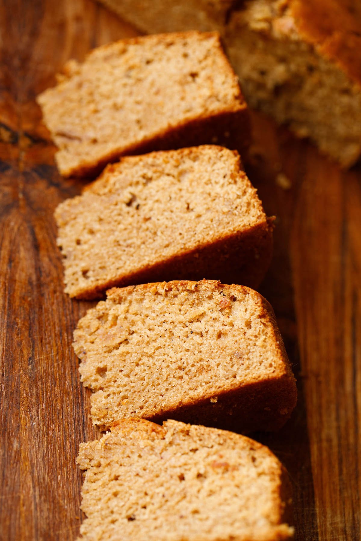 three slices of vegan apple cake on wooden board