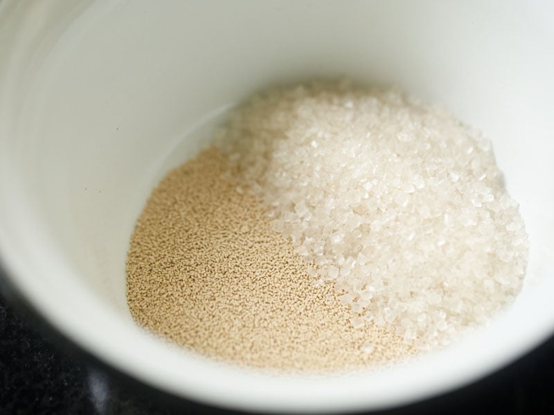 instant yeast granules and sugar in a white bowl