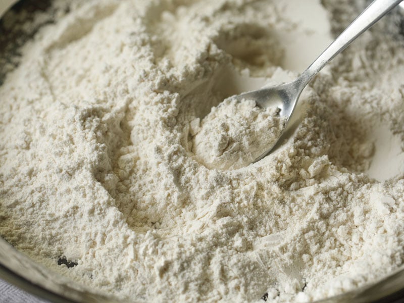 flour and salt being mixed with a steel spoon