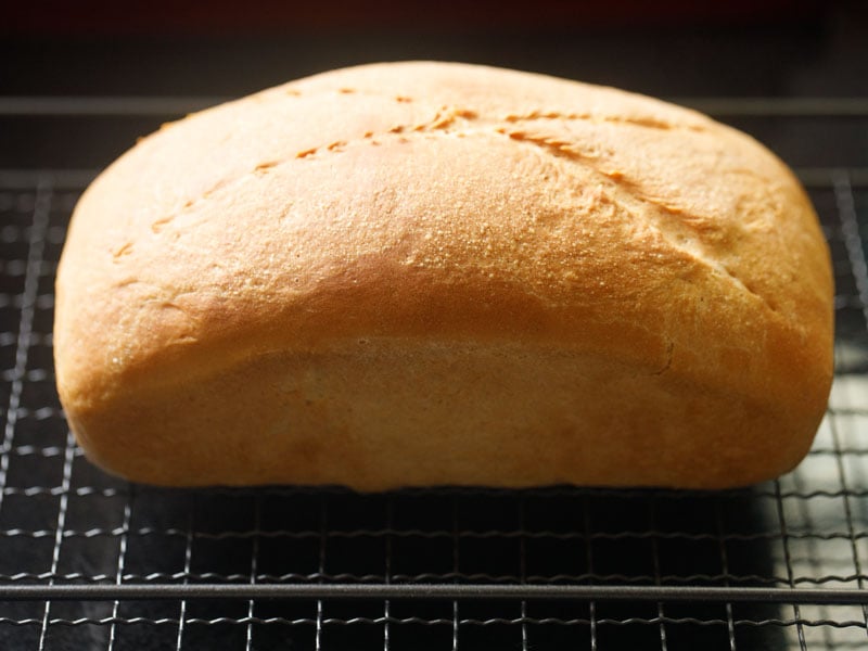 baked white bread placed on a wired rack