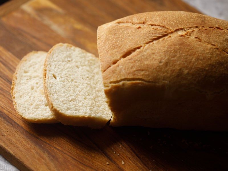 two slices cut from the bread on a brown chopping board