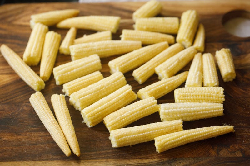 chopped baby corn on a wooden board