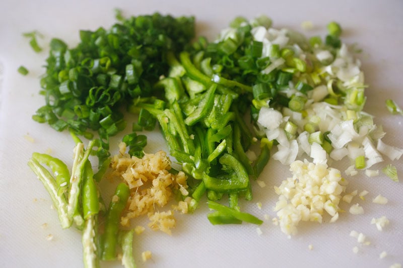 chopped aromatics and capsicum on a white board