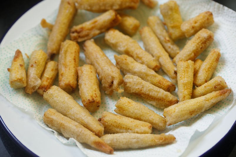 fried baby corn pieces on kitchen paper towel
