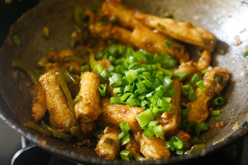 chopped spring onion greens on chilli baby corn