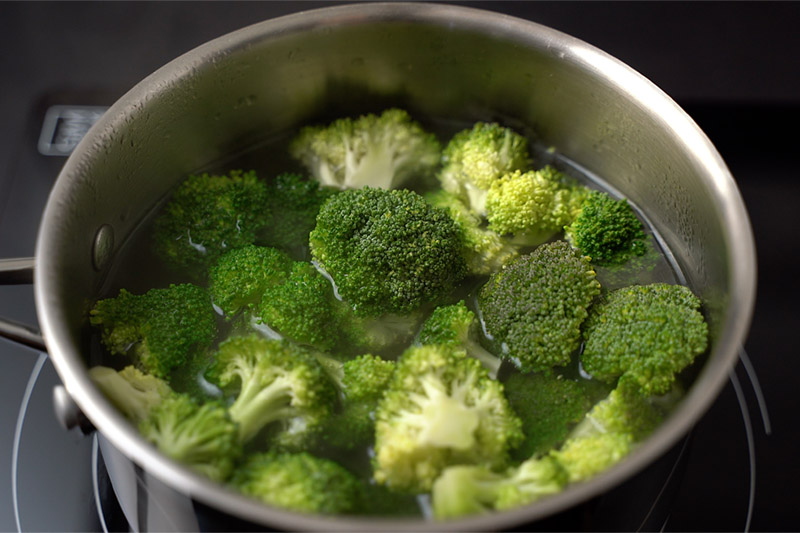 top shot of broccoli in water in pot on stovetop