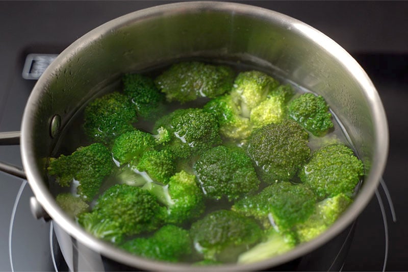 top shot of broccoli getting blanched in hot water in a pot