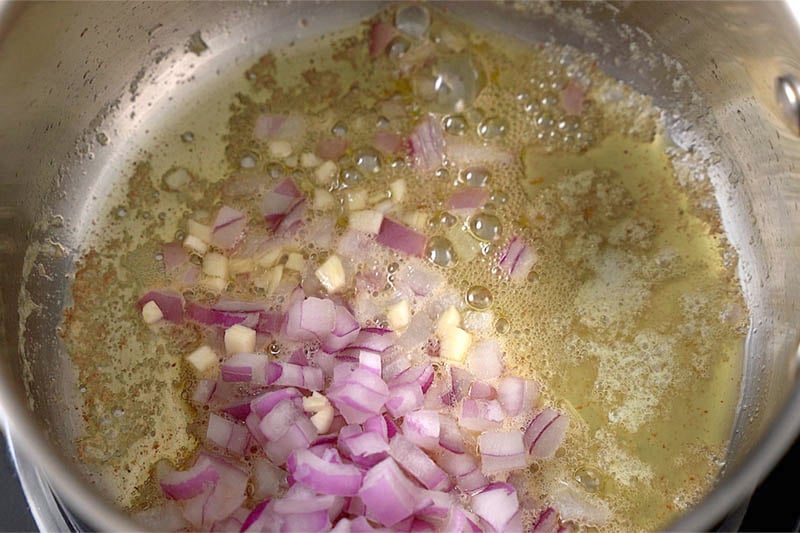 top shot of onions, garlic, and butter cooking in pot