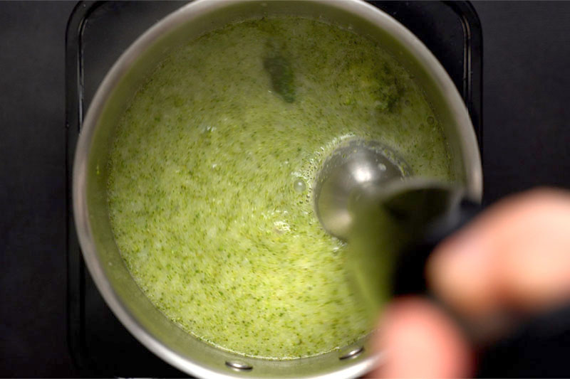 top shot of immersion blender pureeing broccoli soup mixture