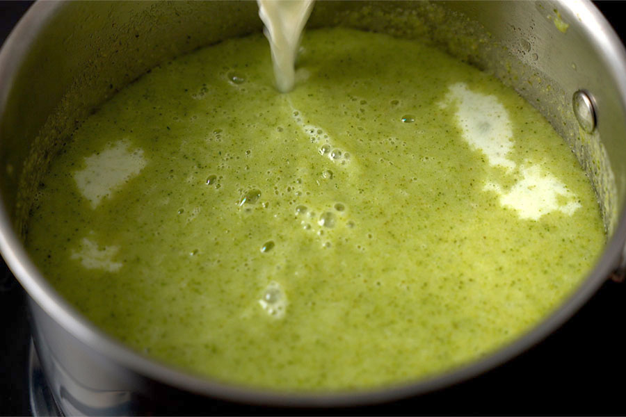 milk being added to the pureed broccoli soup