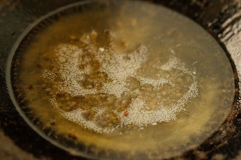 mustard seeds frying in ghee in a kadai (Indian wok)