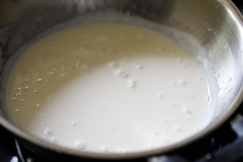 cream simmering in pan to make alfredo sauce