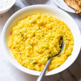 top shot of khichdi in a bowl with a spoon inside