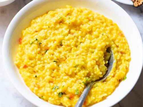 top shot of khichdi in a bowl with a spoon inside