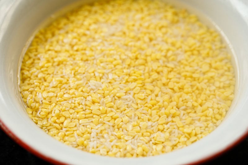 Top shot of soaked rice and lentils soaking in a white bowl