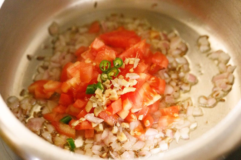 Top shot of chopped tomatoes, ginger and chilis in pressure cooker