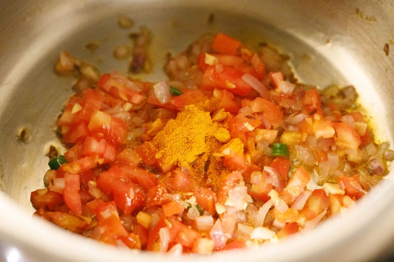Turmeric powder on mixed tomatoes in pressure cooker