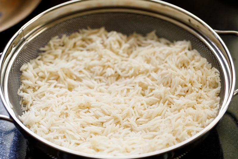 long grained rice in a mesh strainer