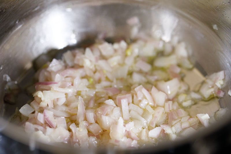 sauteing chopped onions and garlic in a steel pan