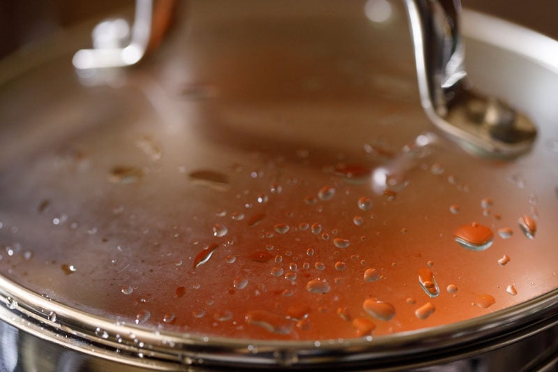 cooking spanish rice in a pan with closed lid