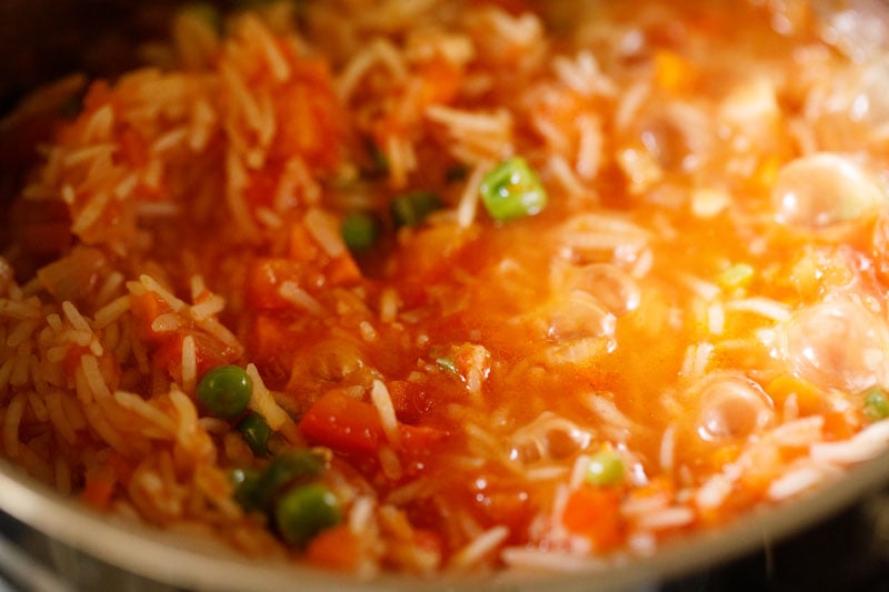 checking cooked rice whether it is cooked or not by removing the lid