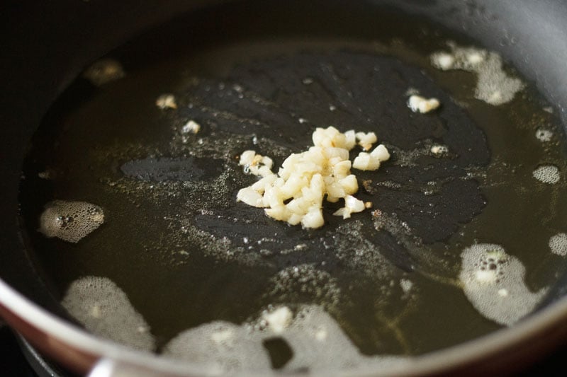 sauté garlic in oil in a black frying pan