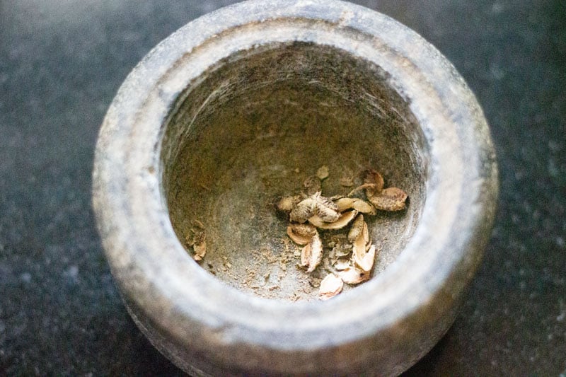 crushing sichuan pepper in stone mortar