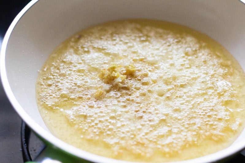 ginger garlic frying in bubbling hot oil