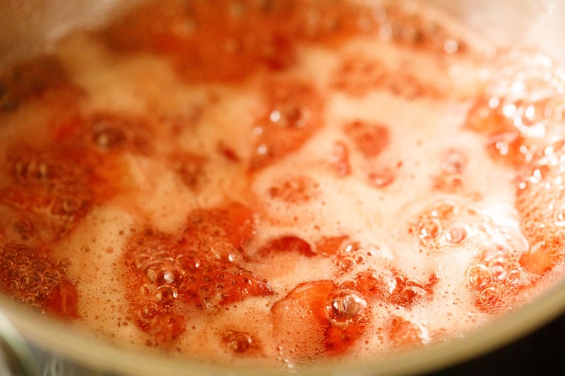 macerated strawberries coming to a boil in a saucepan