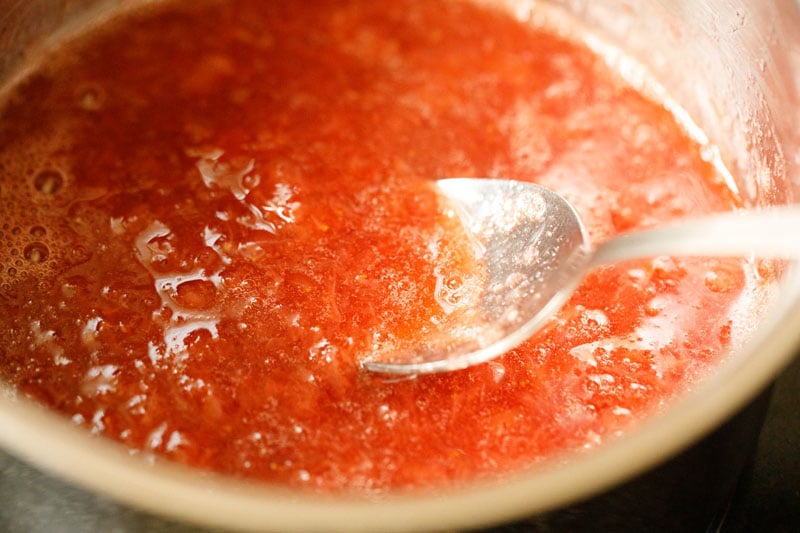 silver spoon in saucepan with strawberry syrup to demonstrate loose consistency