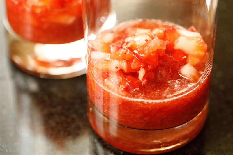 strawberry syrup and chopped strawberries in a clear glass for making Korean strawberry milk