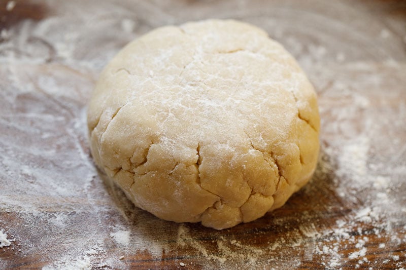 flour sprinkled on wooden board and chilled shortcake dough 