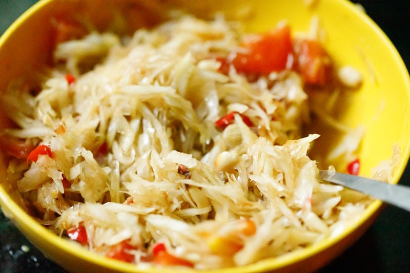 green papaya salad after being tossed with som tam dressing in yellow bowl