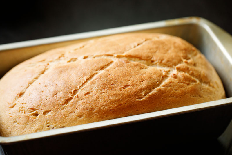 golden and beautifully baked whole wheat bread in loaf pan.