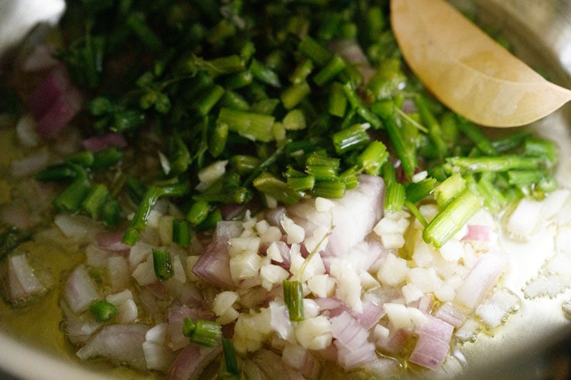 onions, garlic, celery and bay leaf sautéing in silver stock pot