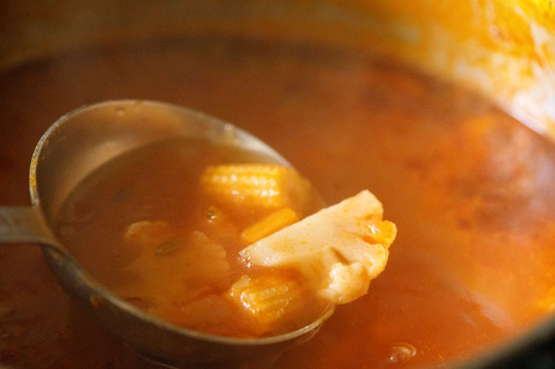 ladleful of minestrone soup above the stockpot