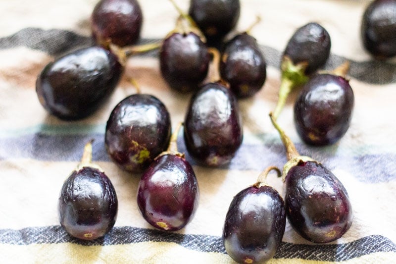 small aubergines on a blue striped kitchen towel