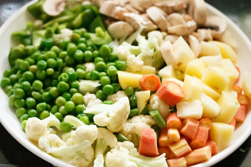 Top shot of chopped vegetables on white plate for veg biryani recipe