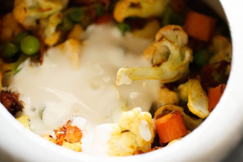 Top shot of curd being added to the veggies