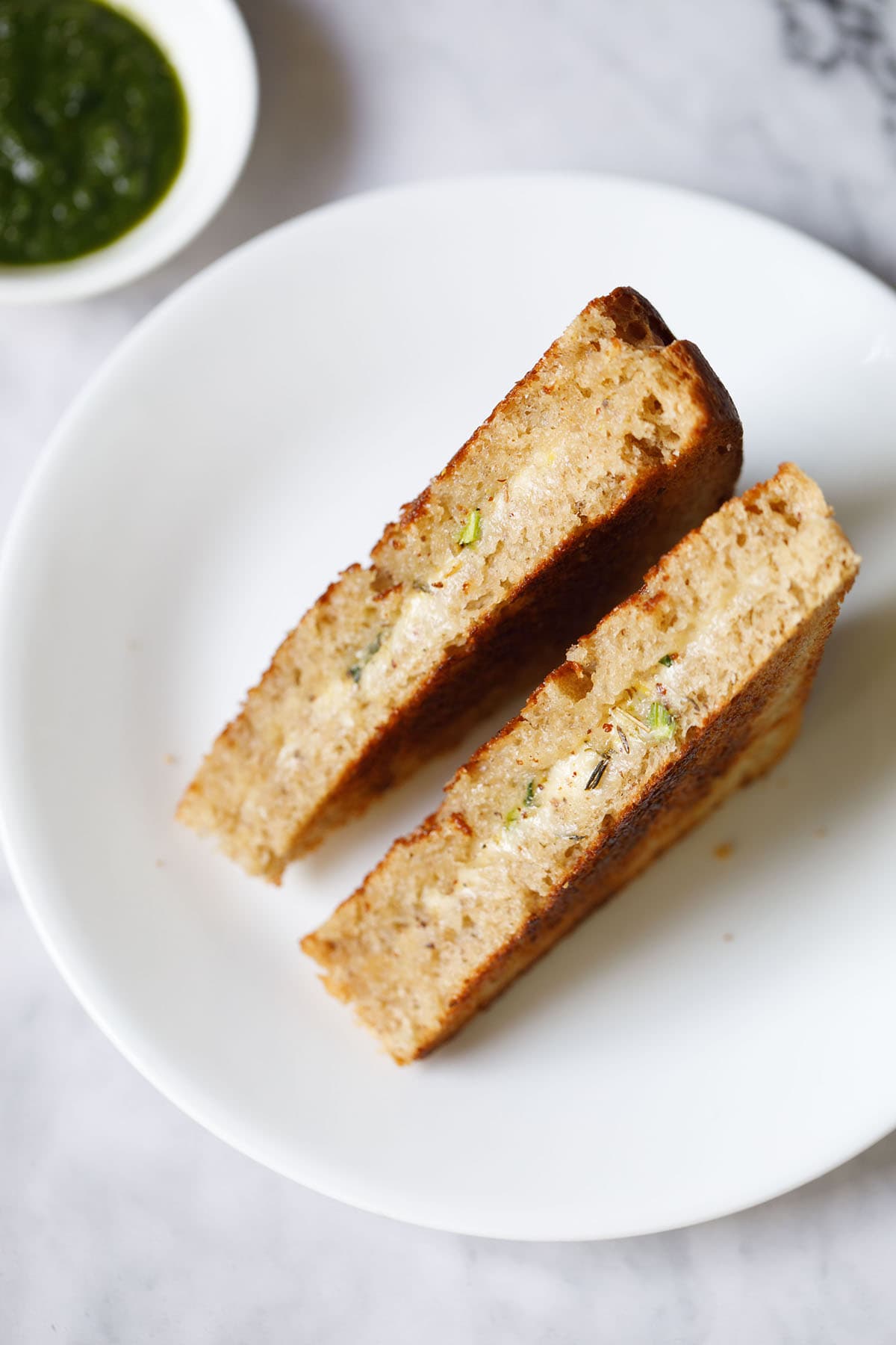 top shot cheese sandwich with the cheesy stuffing in the center on a white plate