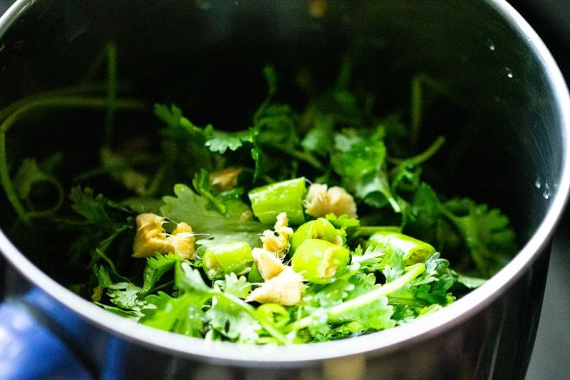 Chopped leaves, garlic and green chili in blender.