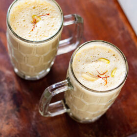 dry fruit milkshake in two glasses on a brown wooden board