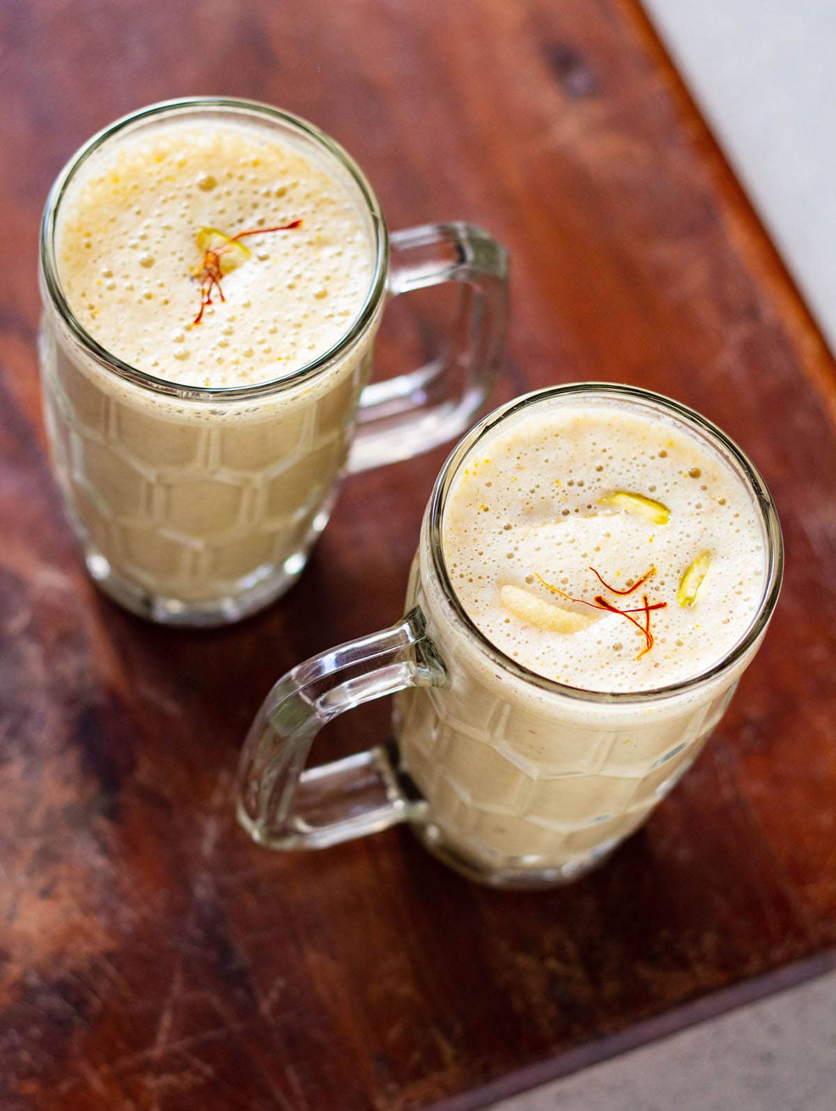 dry fruit milkshake in two glasses on a brown wooden board