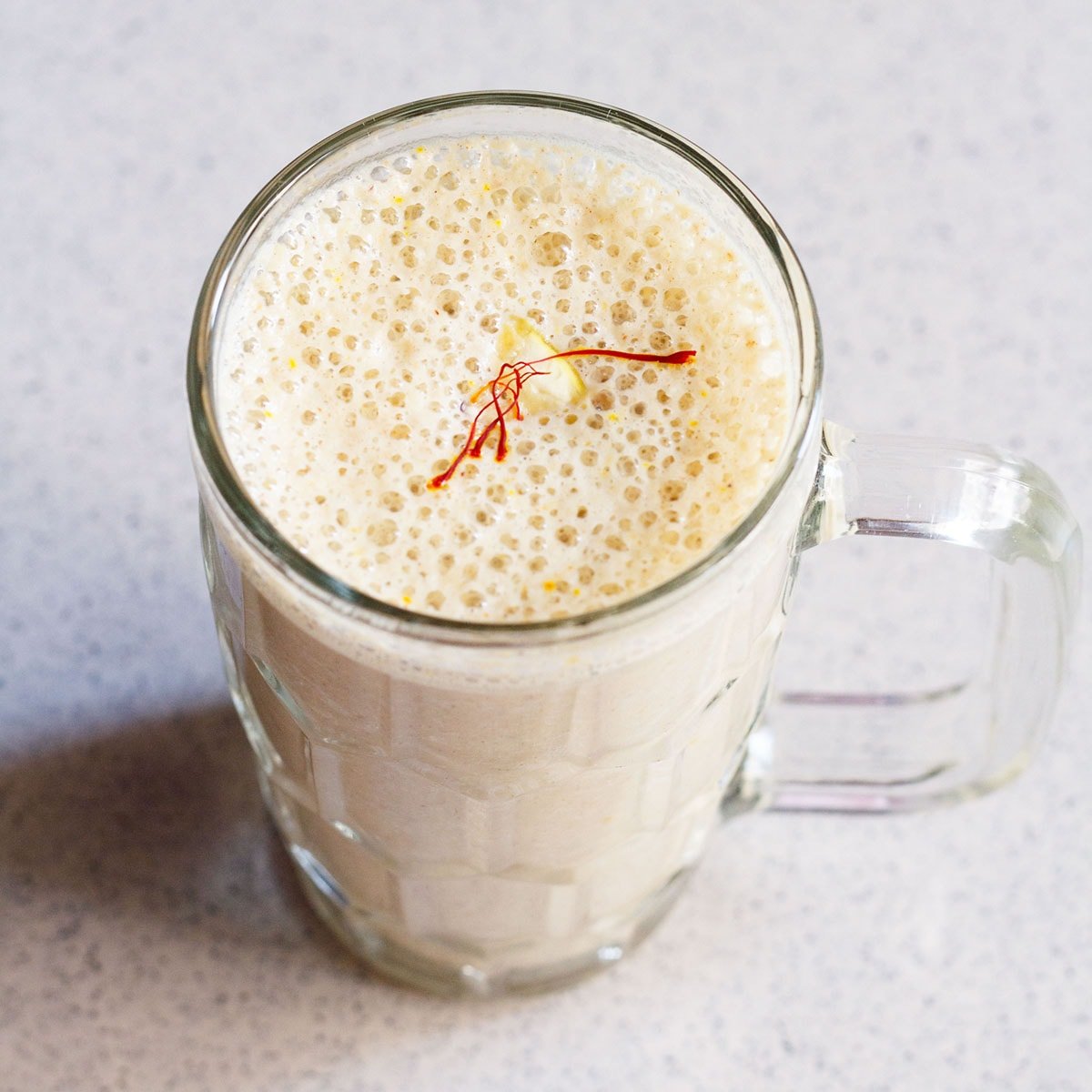 dry fruits milkshake recipe in a glass on a marbled surface