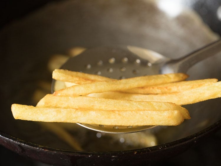 slotted spoon removing finger chips from oil