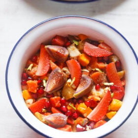 overhead shot of fruit salad in a white bowl with a blue rim