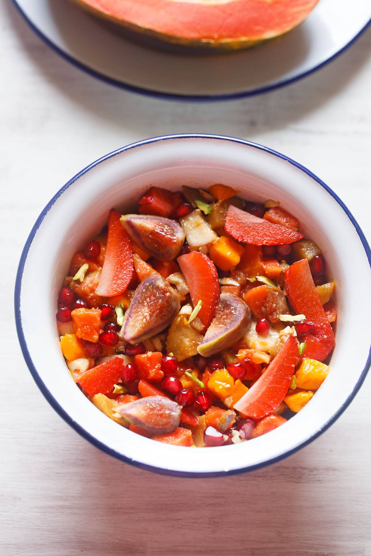 overhead shot of fruit salad in a white bowl with a blue rim