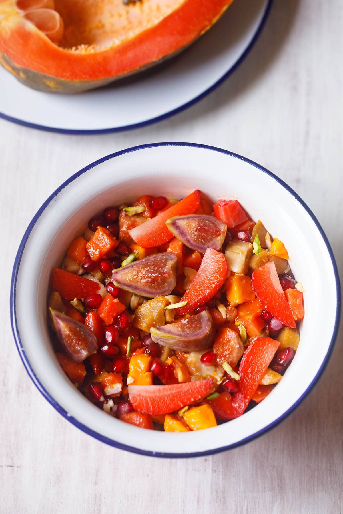 overhead shot of fruit salad in a white bowl with a blue rim